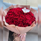 Bouquet of 100 red roses with a white orchid in pink paper wrapping.