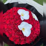 Bouquet of 100 red roses with white orchids on a black base